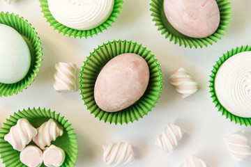 Painted eggs in baskets with marshmallows.Creative Easter background.