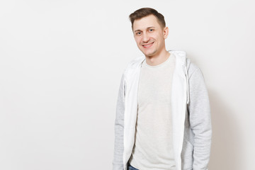 Young handsome happy male student in gray t-shirt and light sweatshirt rejoice and smiling isolated on white background. Concept of man emotions, good mood. Copy space for advertisement.