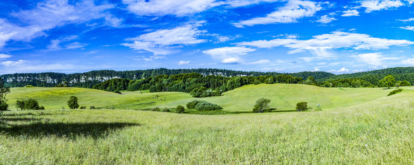 scenic landscape will hills and meadows in Le Frasnois in the Jura region in France