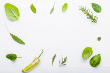 Various fresh herbs for cooking ingrediens peppermint , sweet basil ,rosemary,oregano, sage and lemon thyme on white wooden background with flat lay and copy space.