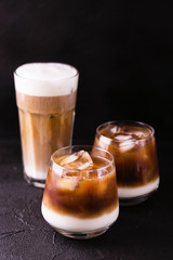 Iced coffee in glasses with milk. Black background