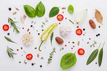 Various fresh herbs for cooking ingrediens peppermint , sweet basil ,rosemary,oregano, sage ,chilli bay leaves and lemon thyme on white wooden background with flat lay .