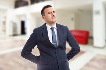 Real estate agent or realtor suffering lower back pain.