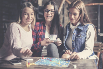 Fototapeta premium Three girls having fun and playing game.