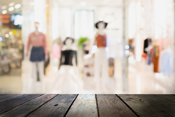 Wooden board empty table blurred background. Perspective brown wood table over blur in cloths shop background - can be used for display or montage your products. Mock up for display of product.