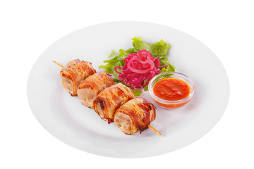 Shish kebab, beef, lamb, pork, chicken in bacon grilled meat, barbecue, without garnish on a plate, isolated on white background. Marinated onion, ketchup, tomato red sauce. Side view For the menu