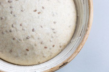 Dough with natural leaven with flax seeds in a rattan basket. The concept of a healthy diet. The style of life.