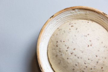 Dough with natural leaven with flax seeds in a rattan basket. The concept of a healthy diet. The style of life.