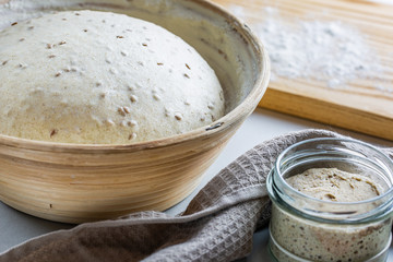 Dough with natural leaven with flax seeds in a rattan basket. The concept of a healthy diet. The style of life.