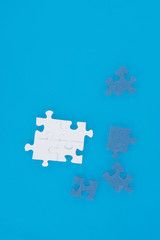top view of white and blue puzzles isolated on blue, business concept