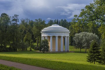 beautiful gazebo in a country Park on a blue sky background with white clouds