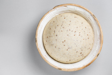 Dough with natural leaven with flax seeds in a rattan basket. The concept of a healthy diet. The style of life.