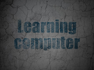 Studying concept: Blue Learning Computer on grunge textured concrete wall background