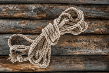 Fototapeta na wymiar top view of tied nautical rope on grunge wooden surface