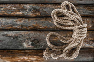 Fototapeta na wymiar top view of tied nautical rope on grunge wooden surface