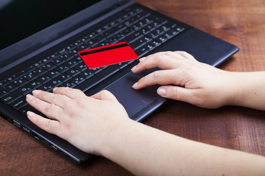 Female hands with a credit card and a laptop