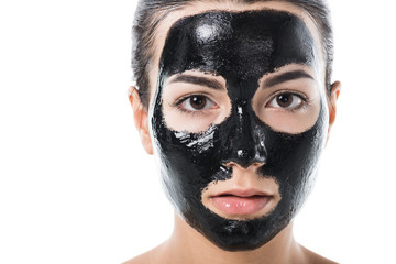 headshot of girl in cosmetic black clay facial mask isolated on white