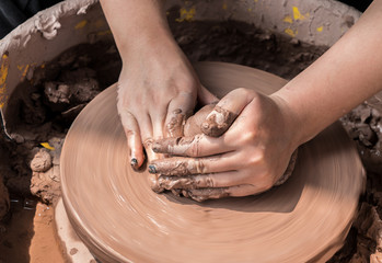 hands of a potter, creating an earthen jar on the circle