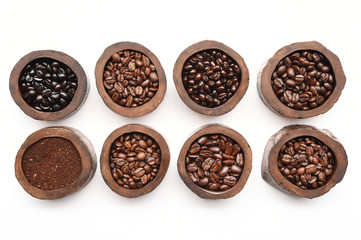 Close up of coffee beans in wooden bowl isolated on white background