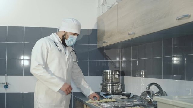 The male nurse wears gloves and checks medical instruments. 4K