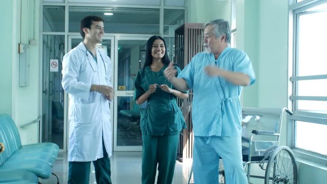 Doctor and patient dance together at hospital. 
