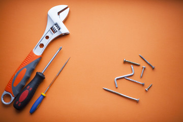 Repair tools on the orange background. Space for your text. Top view.