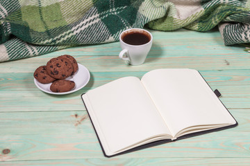 Cup with Hot Tea or Coffee, Warm Plaid, Book on a Wooden Table. with copy space