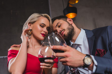 sensual stylish young couple drinking red wine together