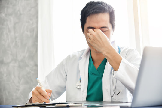 Stressed Young Asian Male Doctor Is Working.