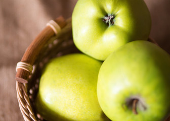 Big fresh green Granny Smith apples in a wooden basket
