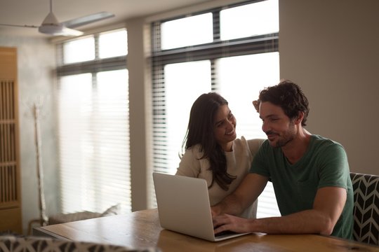 Couple using a laptop while sitting at home