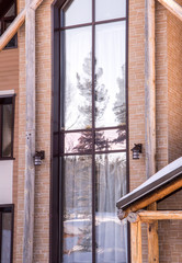 Part of the facade of a brick house in modern style and sun beams