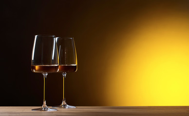 Glasses of white wine on a yellow background.