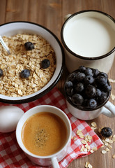 Healthy eating, food and diet concept - tasty oatmeal with berries and a mug of milk and a cup of coffee.Top view.