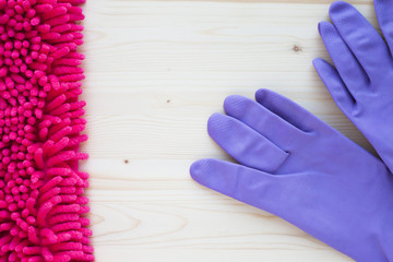 Cleaning Concept. Set of yellow, green, blue, red, white and pink cleaning tools: rags, sponges, brushes, dishwashing liquid, rubber gloves on the wooden background, top view, flat lay, close up