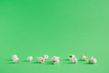 Popcorn snack on green background minimalistic concept.