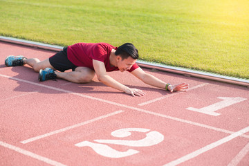 Sad young asian man runner sitting on the ground and cry after losing in competition