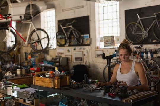 Female mechanic examining bicycle parts