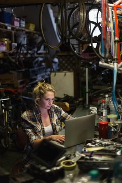 Female mechanic using laptop in workshop