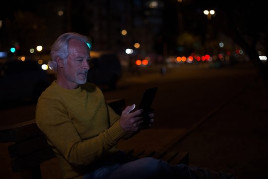 Senior man using digital tablet in city