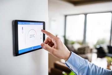 A man pointing to a tablet with smart home screen.