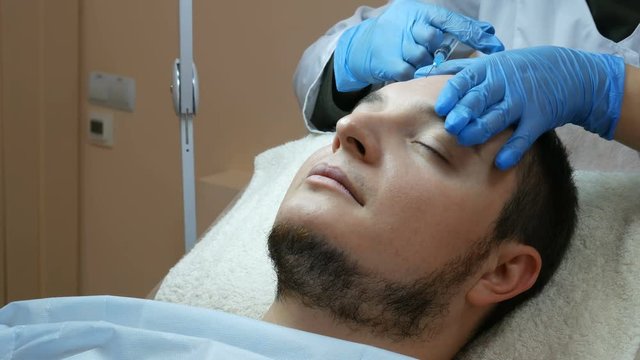 Filler injection for male face in beauty clinic.
