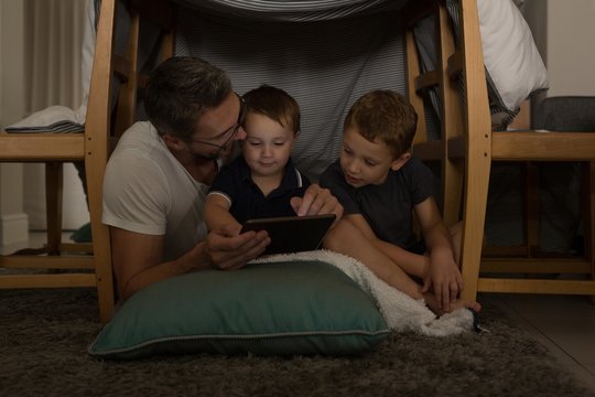Father with his sons using digital tablet