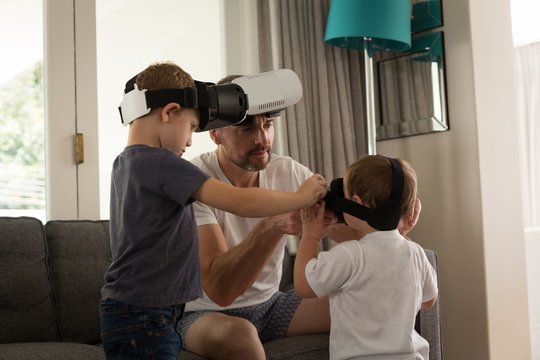 Father helping his son in using virtual reality headset in
