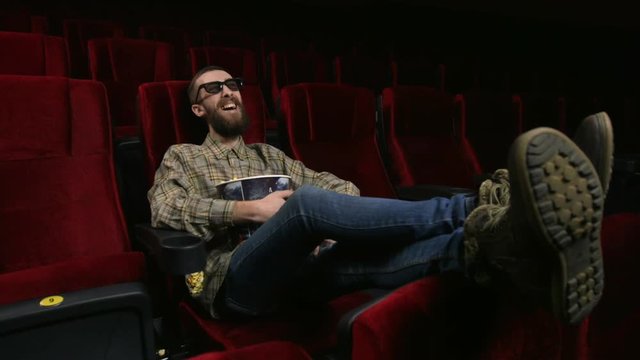 Close up, happy face of a man enjoying a movie at the movie theatre.