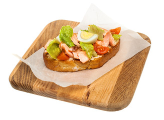 Sandwich with Vegetables and Smoked Salmon on Wooden Plate Isolated on White Background. Salmon, eggs, lettuce and tomatoes on Bread
