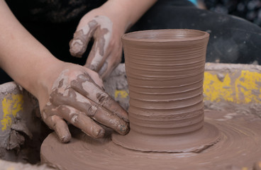 Fototapeta na wymiar hands of a potter, creating an earthen jar on the circle