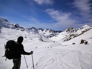 Fototapeta na wymiar male backcountry skier looks at mountain landscape and his goal for the day's backcountry ski tour