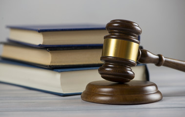 Wooden mallet used by a judge or at an auction next to a book. Concept