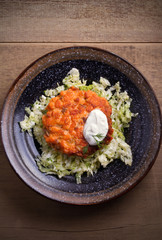 Salmon burger and cabbage salad in bowl on wooden table. Salmon fish cake and vegetables. overhead, vertical